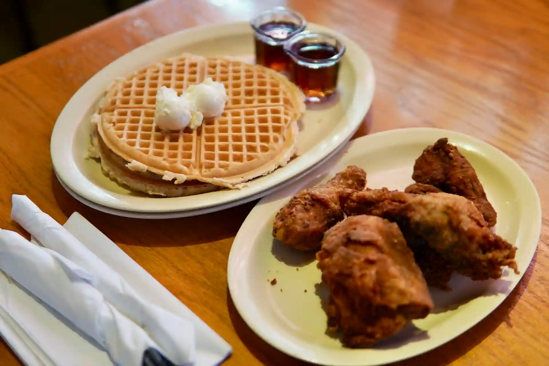 Assiettes contenant des "Chicken Waffles", une spécialité de la Soul Food américaine, avec du miel et de la glace vanille.