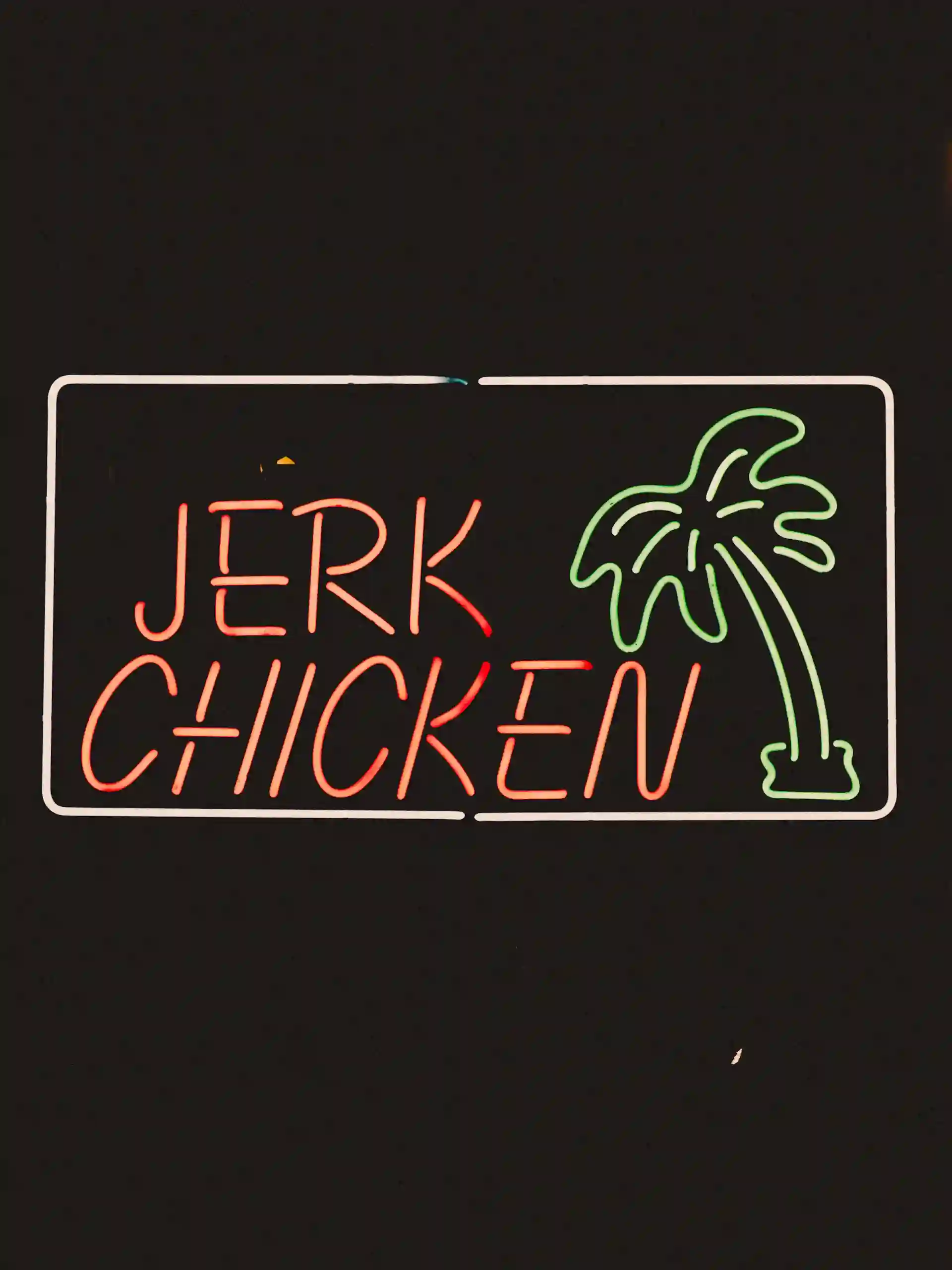 Logo lumineux d'un restaurant dans lequel est inscrit "Jerk Chicken"